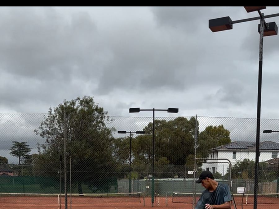 Coach demonstrating an agility drill on the clay courts at Holy Saviour Tennis Club